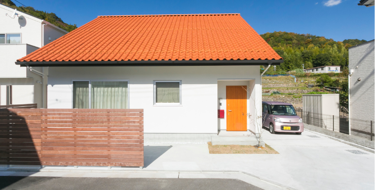 オレンジ色の屋根と白い外壁が特徴のカントリーテイストな家の外観