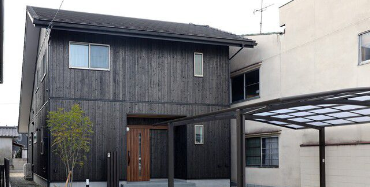 黒い外壁とカーポートが特徴的な家の外観