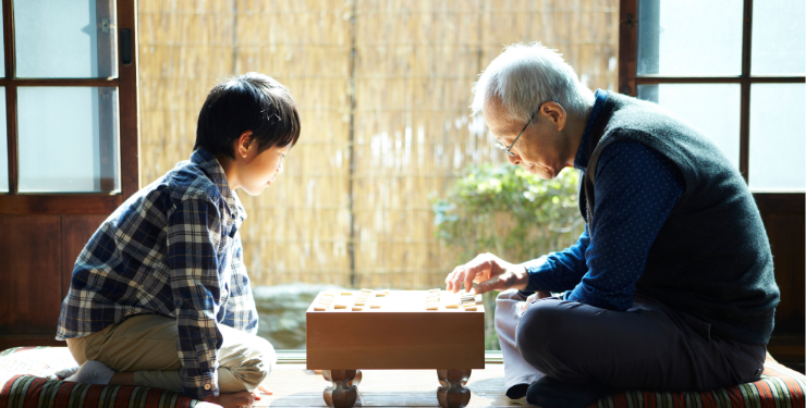 おじいさんと子どもが将棋を打つ風景