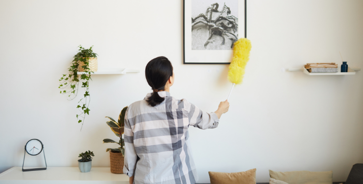 家の壁掛けを掃除している女性