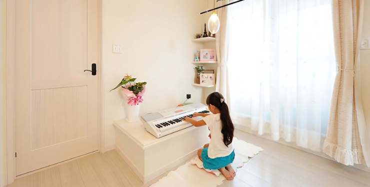 子ども部屋で女の子がピアノを弾いている様子