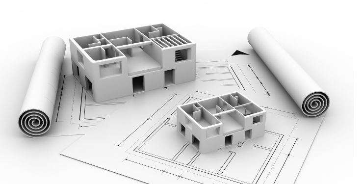 間取り図の上に建設途中の家の模型が乗っている