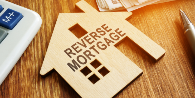 REVERSE MORTGAGEと書かれた家のパネルが机の上に置かれている